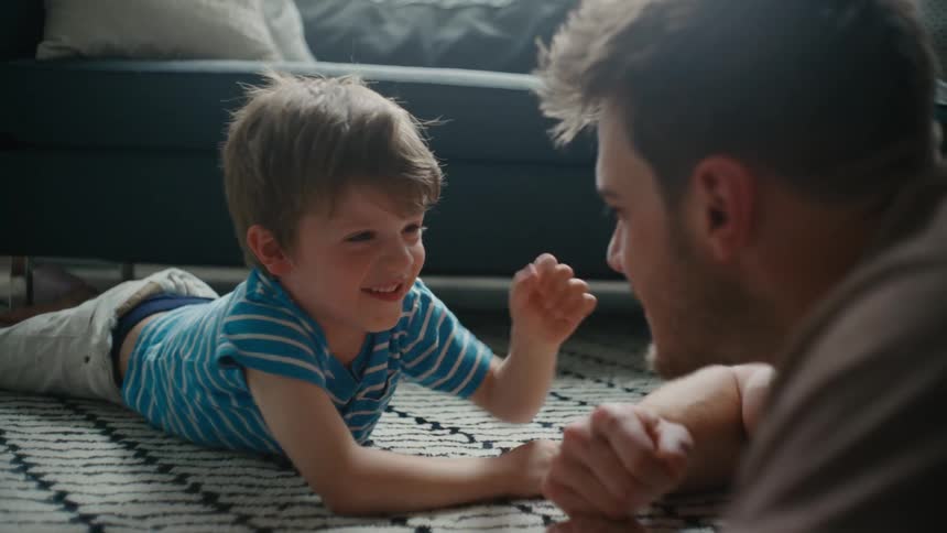 Father lying on the floor playing with his male child