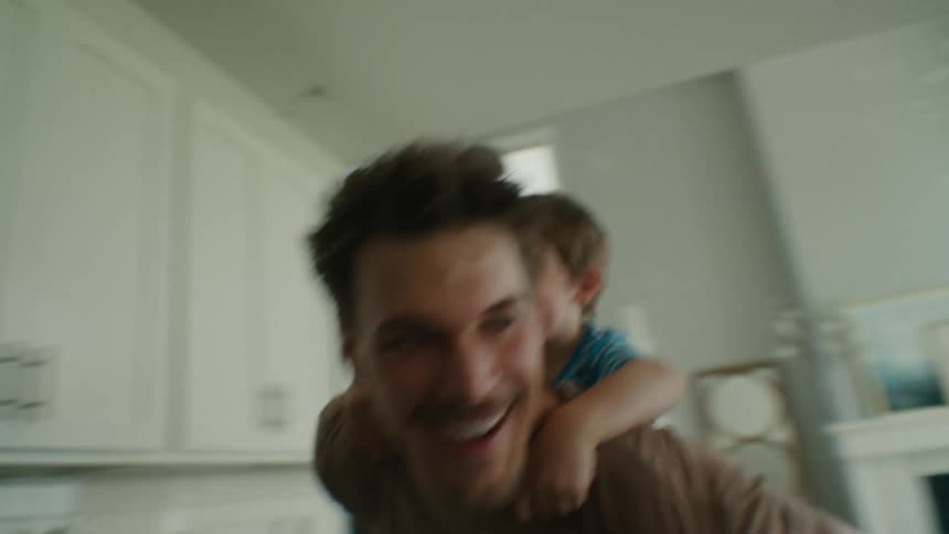 Father and Son Laugh Together During a Piggyback Ride at Home