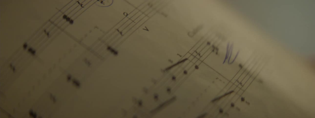 Persons hand leaving through pages of a music sheet