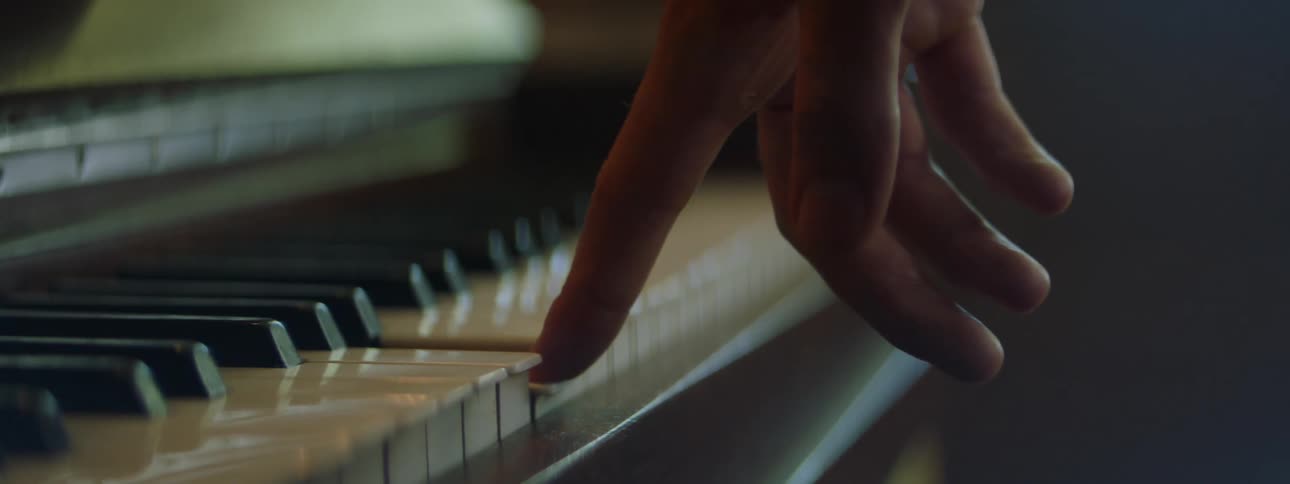 Close up view of a person touching a piano