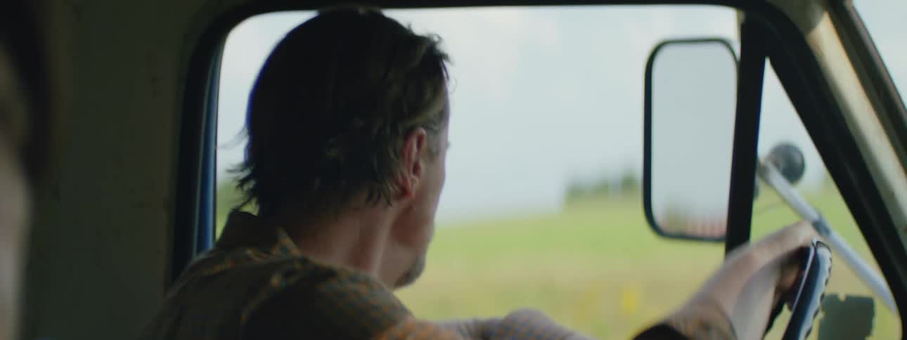 A man driving his pickup truck while looking at his passenger and becoming stressed while grabbing the wheel
