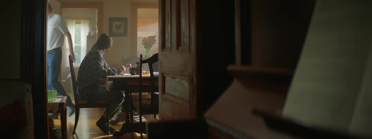 Father dons hat and leaves just before son finishes eating and gets up