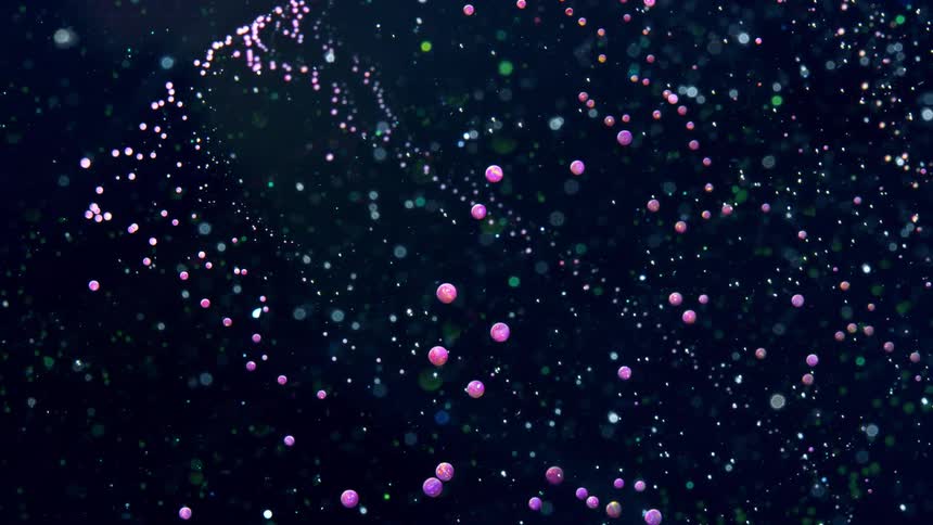 Red and purple spheres float one direction while spots float the opposite direction against a black background