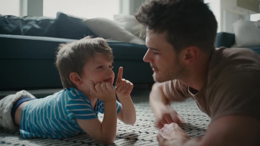 Father and son in the room playing by touching each others nose