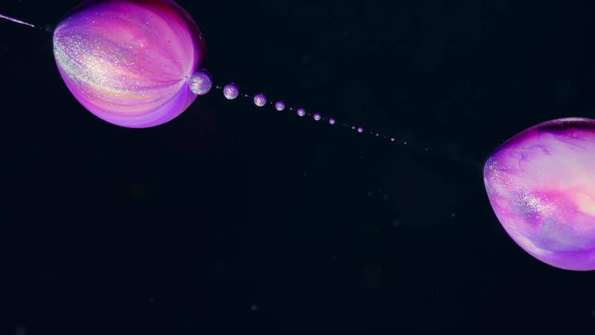 Abstract footage of purple and silver bubbles moving like liquid planets