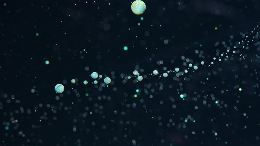 Abstract colored spheres orbiting around in a dark space