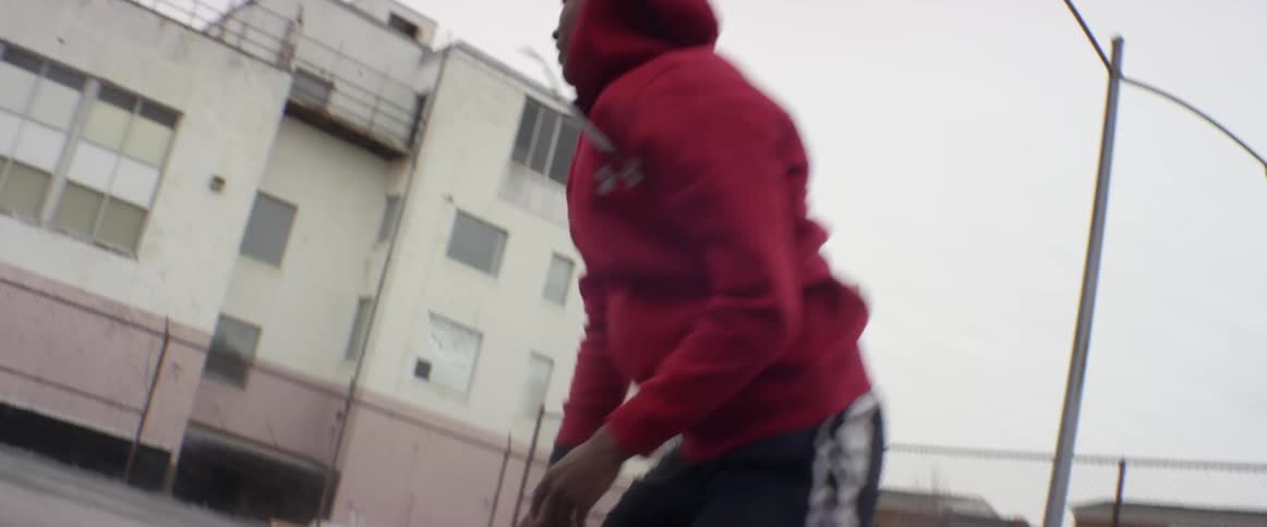 Man does a pushup on an outdoor basketball court