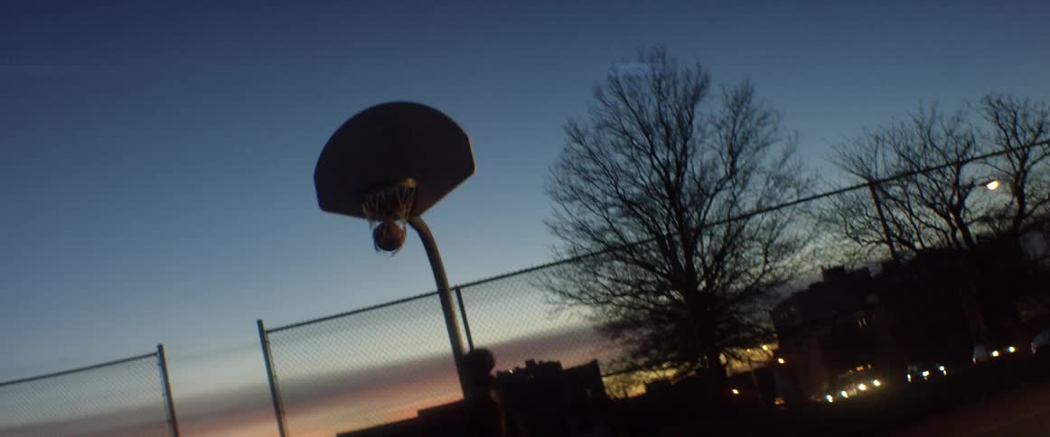 A man does a lay up at dawn