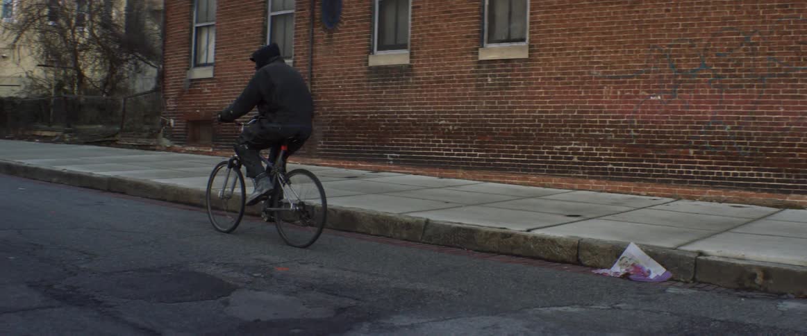 A man rides his bike down the street