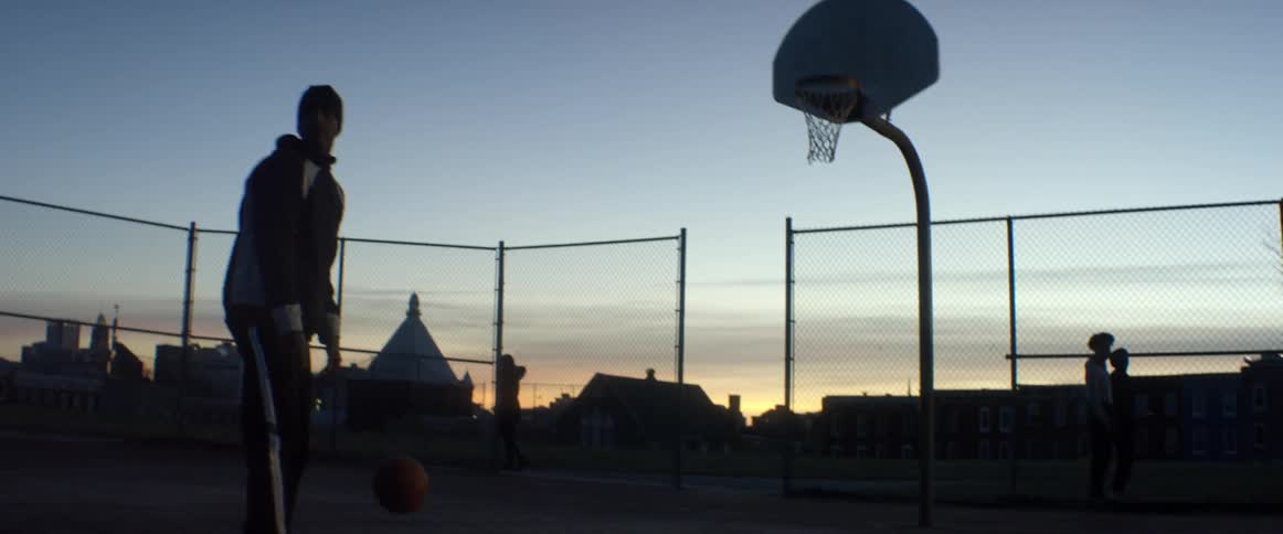 A man who is dribbling a basketball suddenly stops