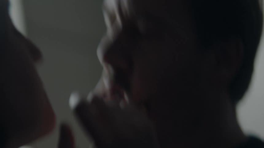Intense moment as a woman confronts a man firmly holding his chin
