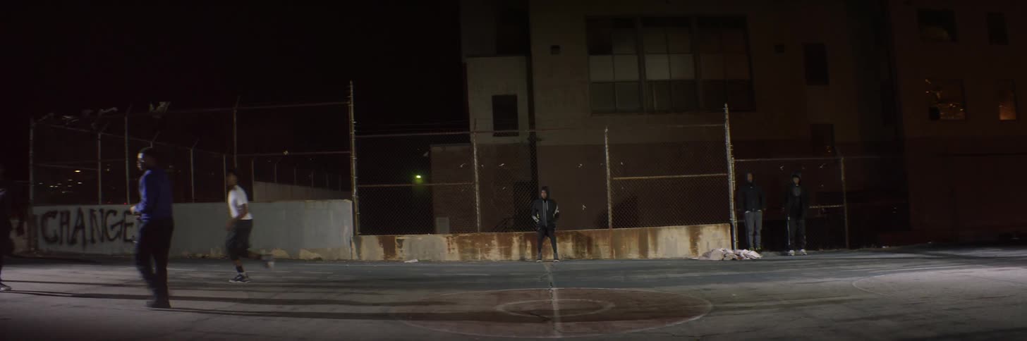 People are playing basketball at night