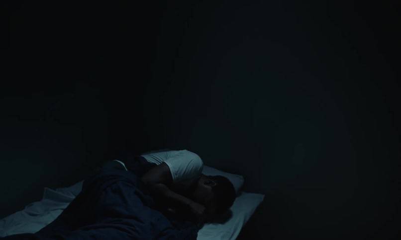 The view is of a portrait of a man that is laying in his bed