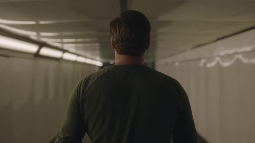 A man walking alone in a tunnel during the night