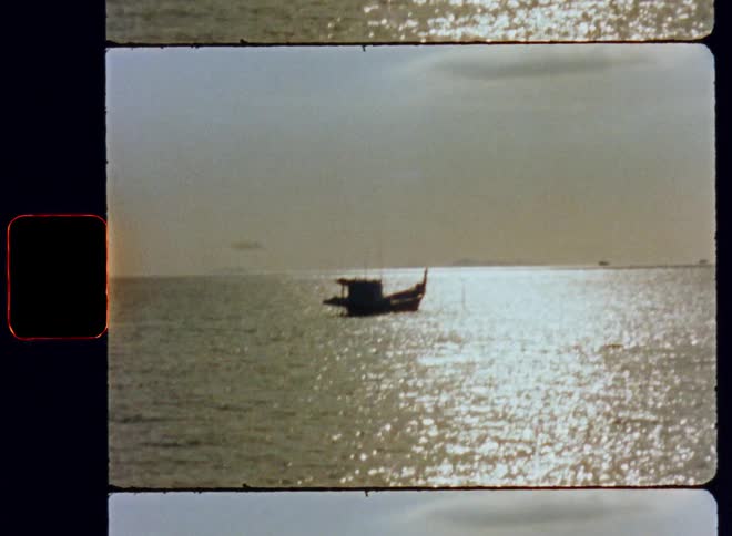A silhouette of a boat on the open water as the sun reflects off the rippling surface