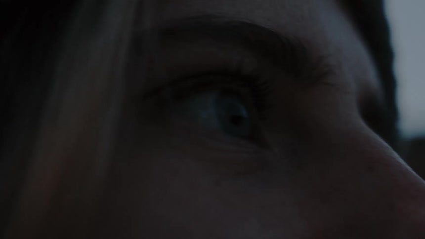 An up close of a persons face wearing a cap with a headlamp while they look around