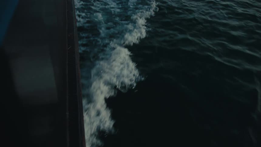Close up view of waves and a boat is displayed