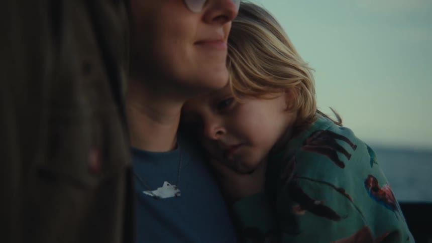 Joyful mom hugging her husband holding their daughter