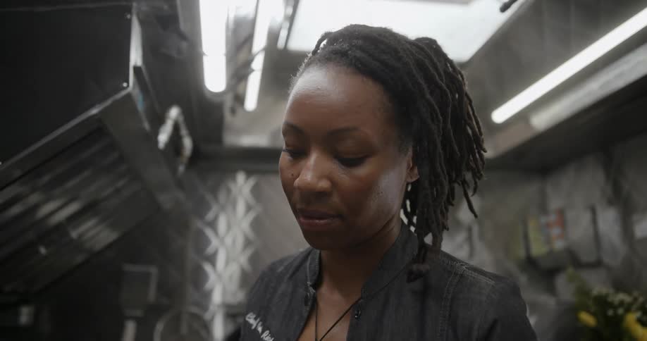 A woman is looking at something in the small room