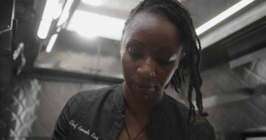 A woman looking down as if she is preparing food in a food truck