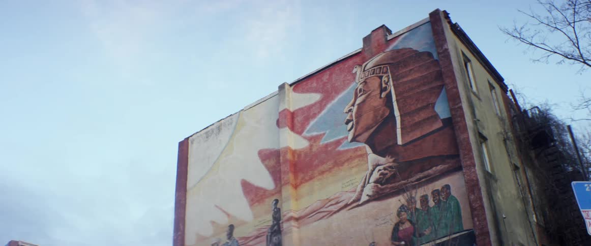 A multi-story building has a mural on its side
