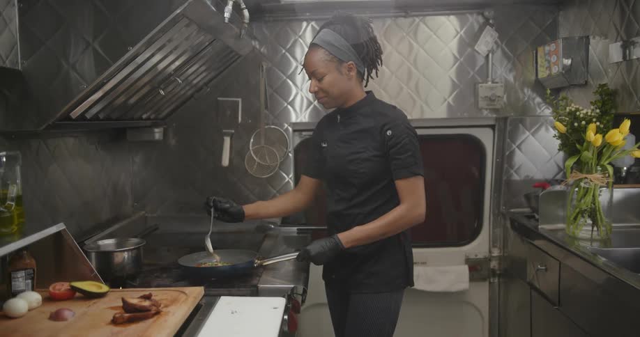 Woman chef cooking in a frying pan on the stove