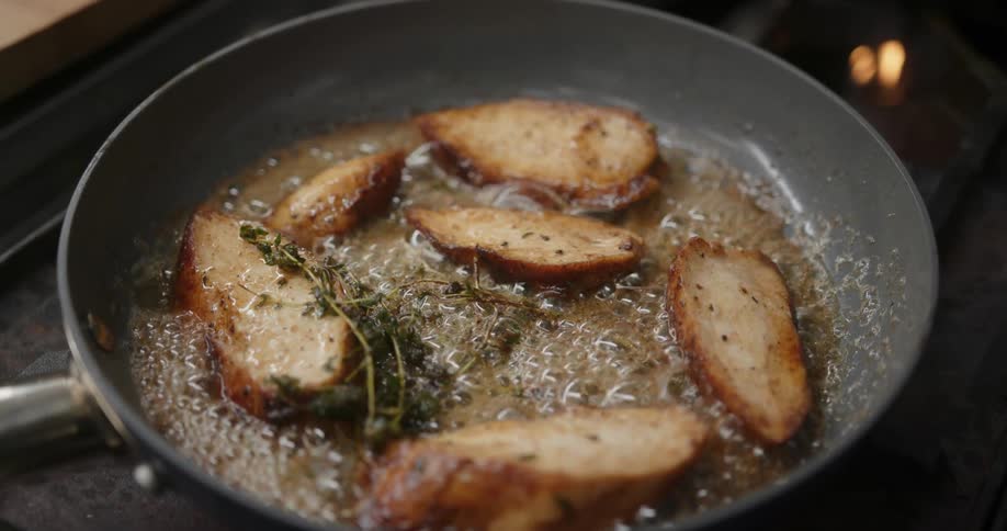 Browning chicken tenders on a grey skillet