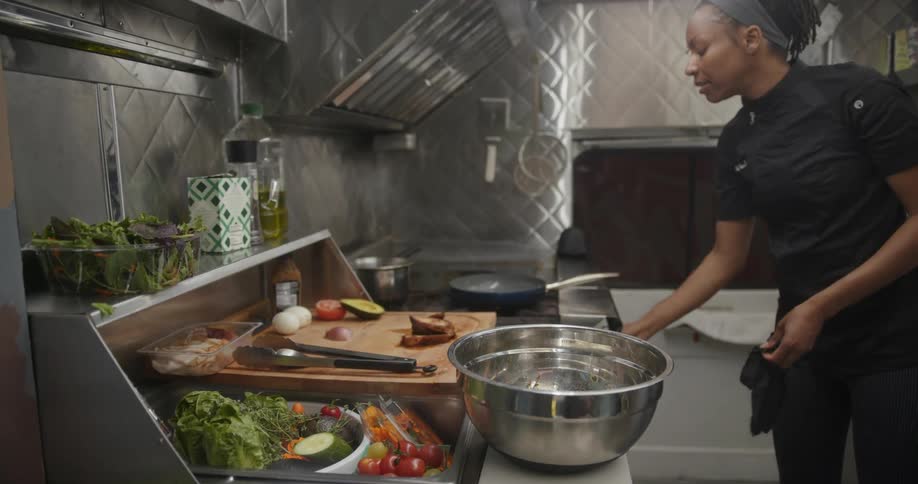 A woman cooks a meal in a restaurant kitchen
