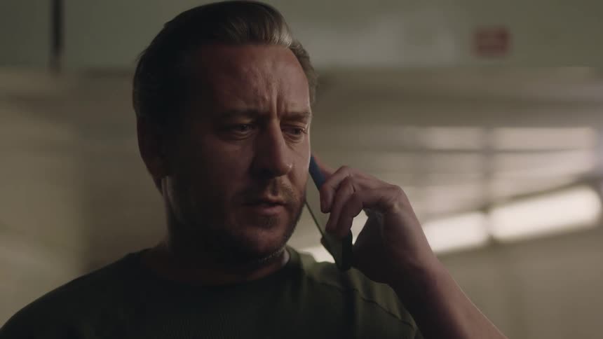A man makes a call on a smartphone with a concerned expression on his face