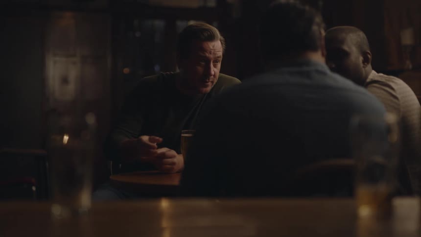 Friends drinking beer and chatting at a bar table