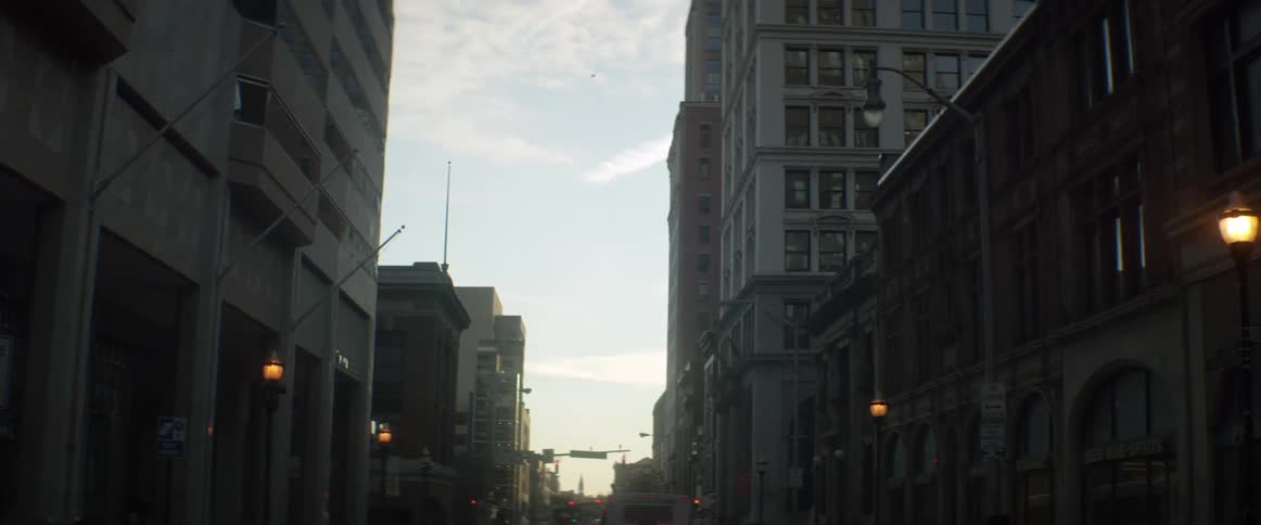 A busy city street has flickering lamp posts