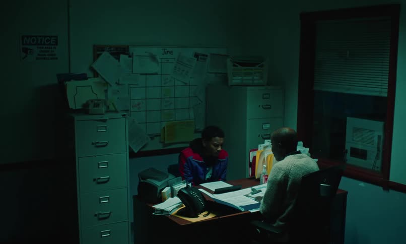 Black man and woman at a desk in an office having a tense conversation