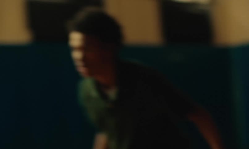 Teenage boys running on a court as they play basketball