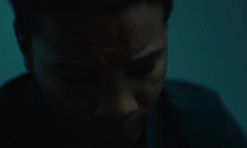 A close up of a teen boys face as he cries and is upset talking to someone