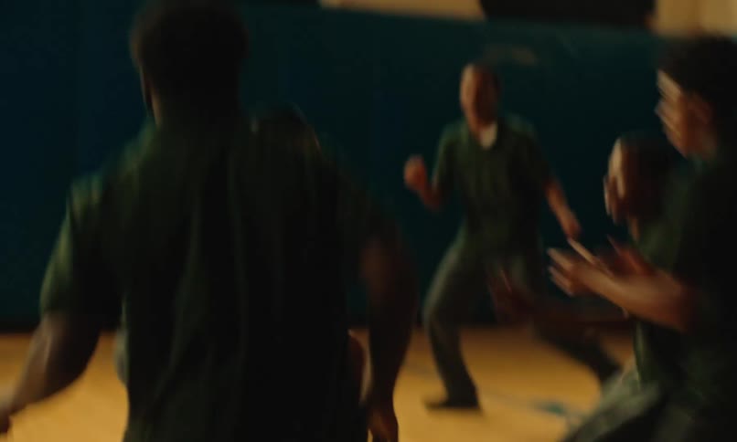 A group of men in prison play basketball