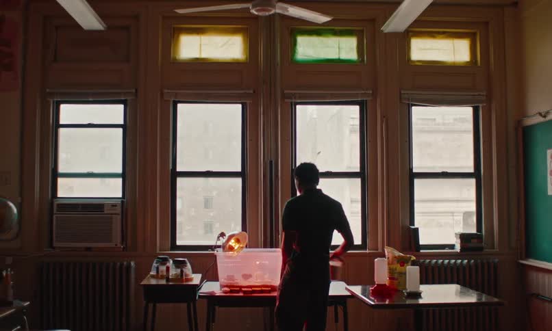 Teenage boy walking into a classroom toward a table with a bin on it that is lit up