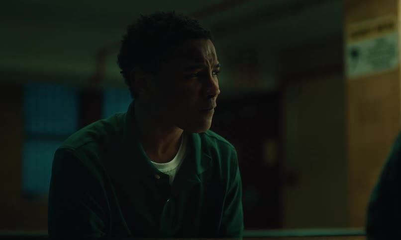 A black male talking while sitting in a dark room
