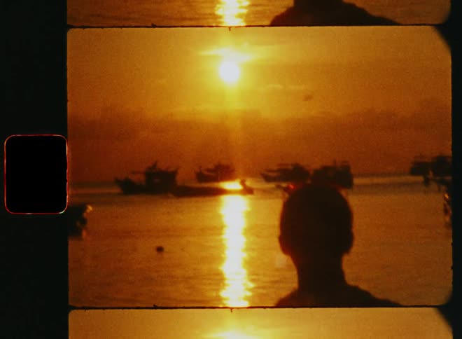 Silhouette of a woman standing in a harbor with boats during sunset