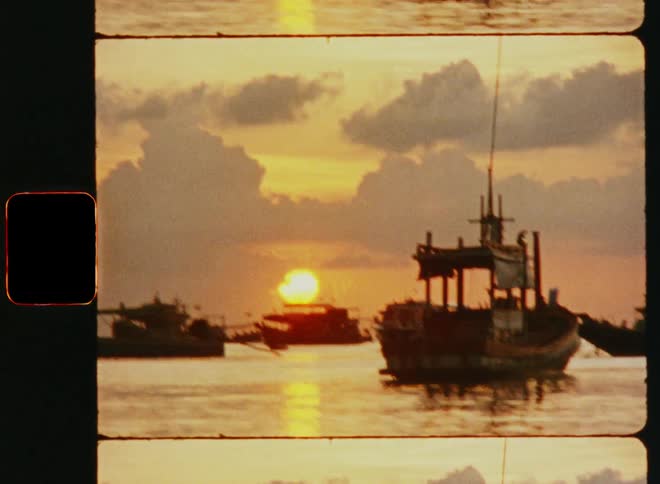 A group of small boats and barges sailing at sunset through a filmlike instagram filter