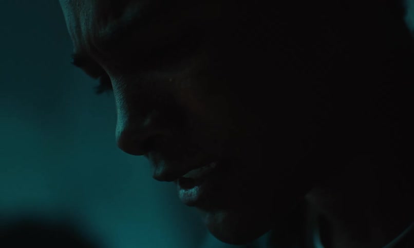 Close up of man talking with a serious facial expression in a poorly lit area