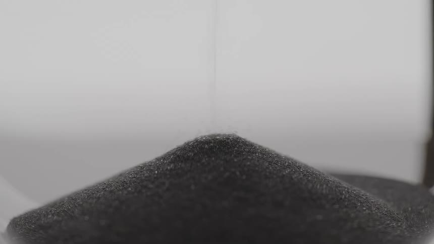 Fine particles fall down to create small gray mound