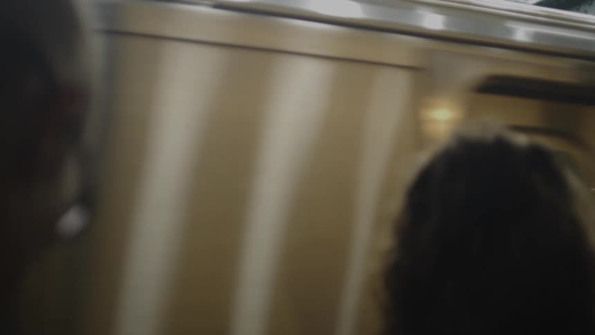 Two peoples heads close up as they wait for a subway train