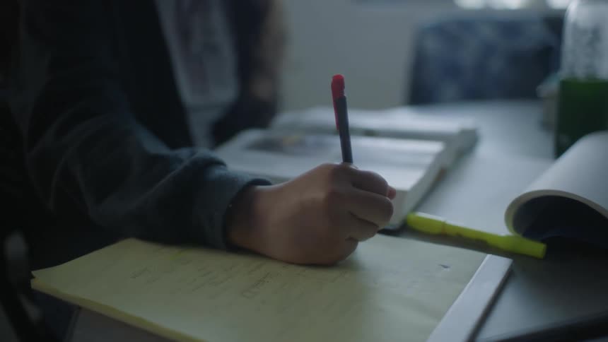 Person in a classroom studying and writing down notes