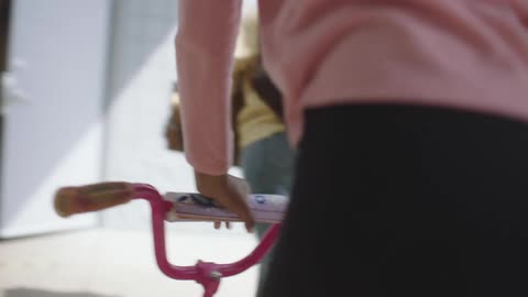 Two women getting a bike and a box of items out of the back of a van