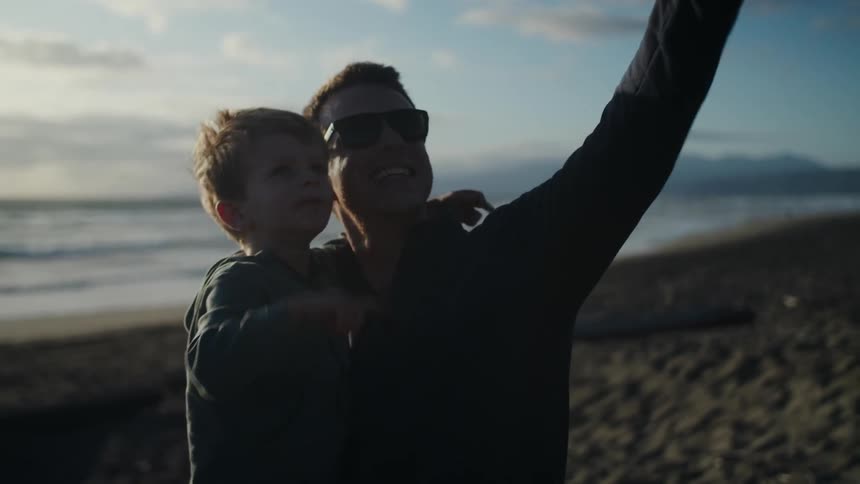 Father holding his son and pointing to show him the sky
