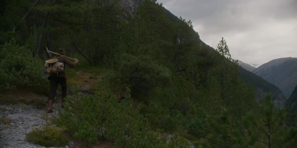 A man is hiking up a mountain landscape during spring
