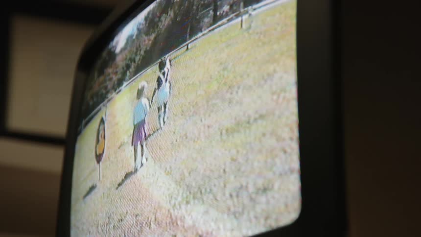 Shot of another video on a television screen showing two children playing outdoors