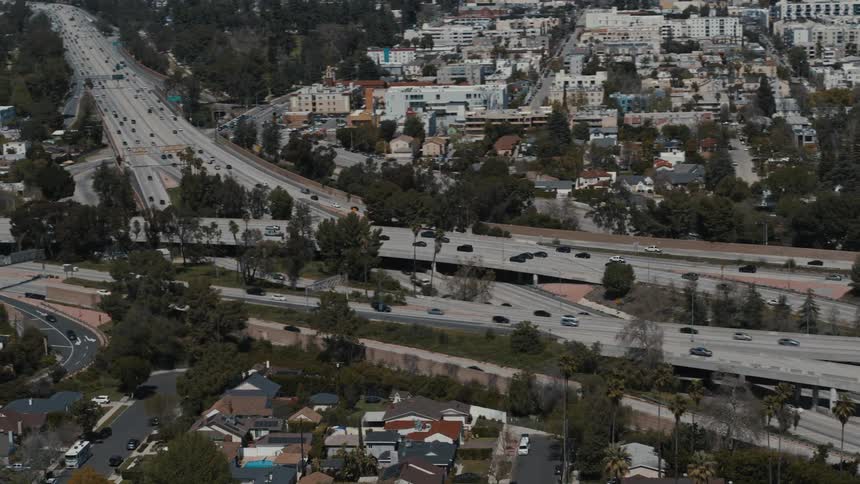 Traffic travels along a freeway interchange through Los Angeles during the day