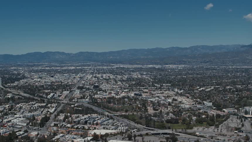 Drone view of a city with buildings houses and intersections with cars traveling on it