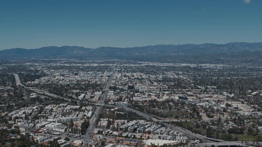 Aerial tracking shot shows intersecting streets and highways in Los Angeles, California